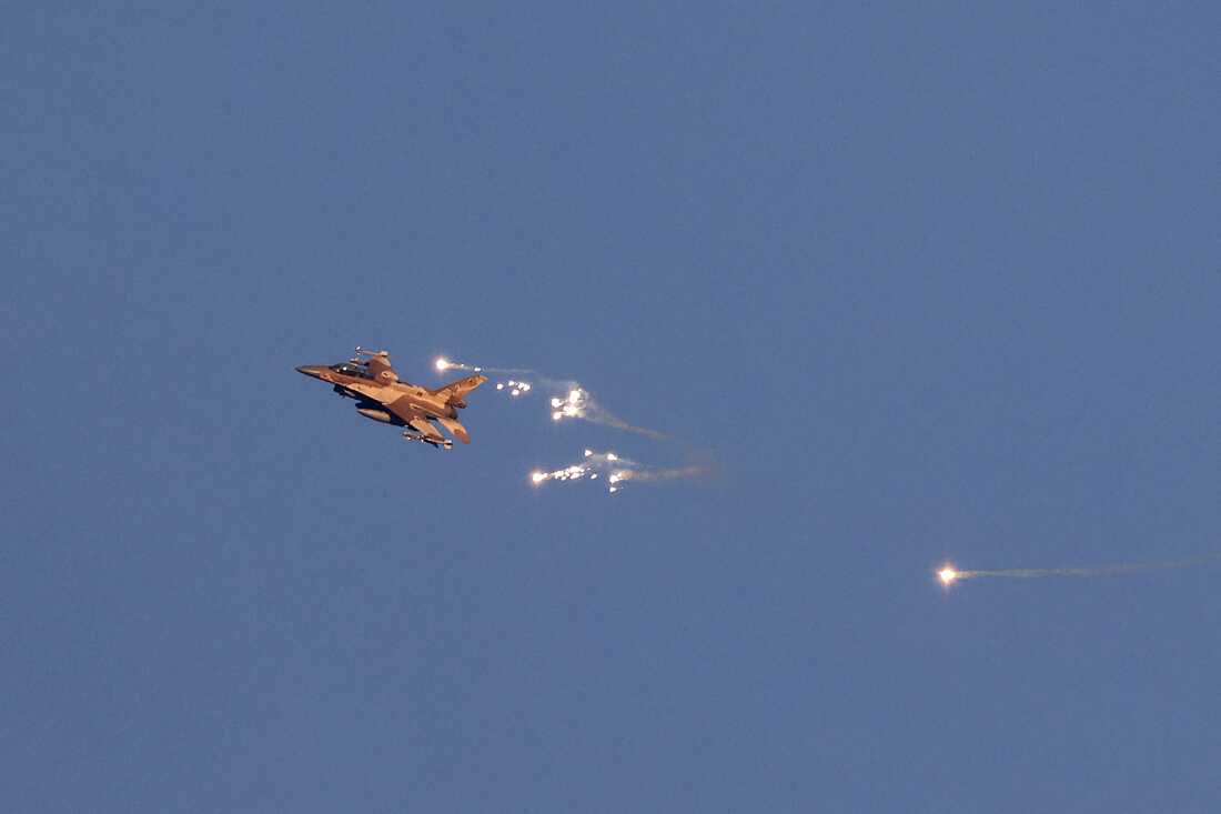 This photo taken from a position in northern Israel shows an Israeli Air Force fighter jet firing flares as it flies to intercept a hostile aircraft that launched from Lebanon over the border area with south Lebanon on Sunday.