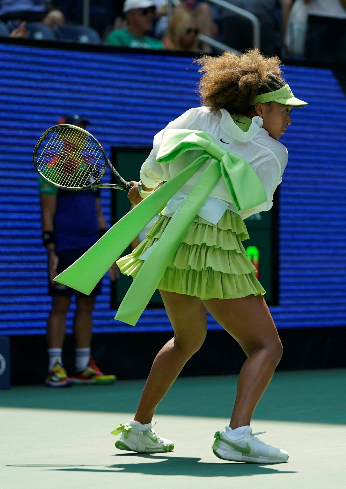 Osaka warmed up in an eye-catching lime-green design on Tuesday, and played her match with bows at her waist and on her heels.