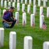 A man places flowers in front of headstones in Section 60, which mark the final resting place of service men and women at Arlington National Cemetery on May 27 in Arlington, Va. Originally known as Decoration Day, Memorial Day began after the Civil War to commemorate soldiers who died in that conflict and now honors all Americans who have sacrificed their lives in all wars.