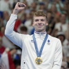 Leon Marchand, of France, celebrates after receiving his first gold medal for in the men's 400-meter individual medley final at the 2024 Summer Olympics, Sunday, July 28, 2024, in Nanterre, France. (AP Photo/Matthias Schrader)