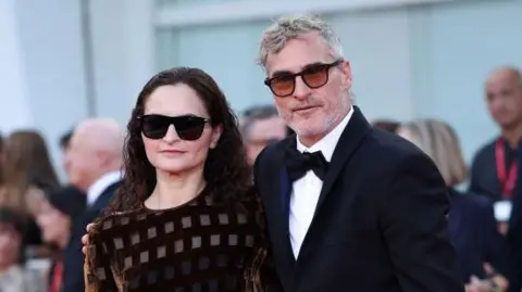 Getty Images Rain Phoenix in dark glasses at the premiere with her brother Joaquin