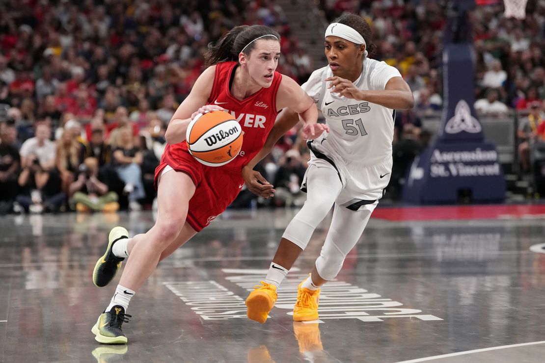 Caitlin Clark dribbles the ball while being guarded by Sydney Colson during the game.