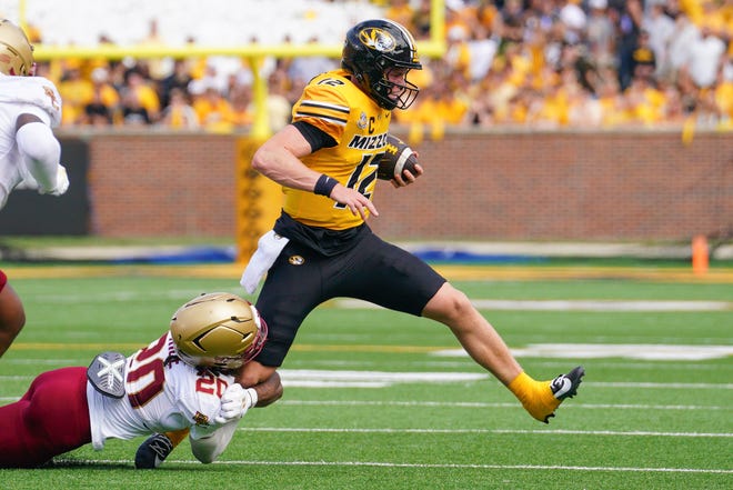 Sep 14, 2024; Columbia, Missouri, USA; Missouri Tigers quarterback Brady Cook (12) runs the ball as Boston College Eagles defensive back KP Price (20) makes the tackle during the first half at Faurot Field at Memorial Stadium. Mandatory Credit: Denny Medley-Imagn Images