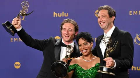 Getty Images Jeremy Allen White, Liza Colon-Zayas and Ebon Moss-Bachrach pose together smiling with their Emmy Awards