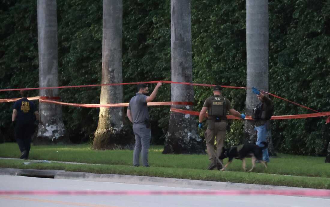 Law enforcement personnel investigate the area around Trump International Golf Club after an apparent assassination attempt of former President Donald Trump on Sunday.