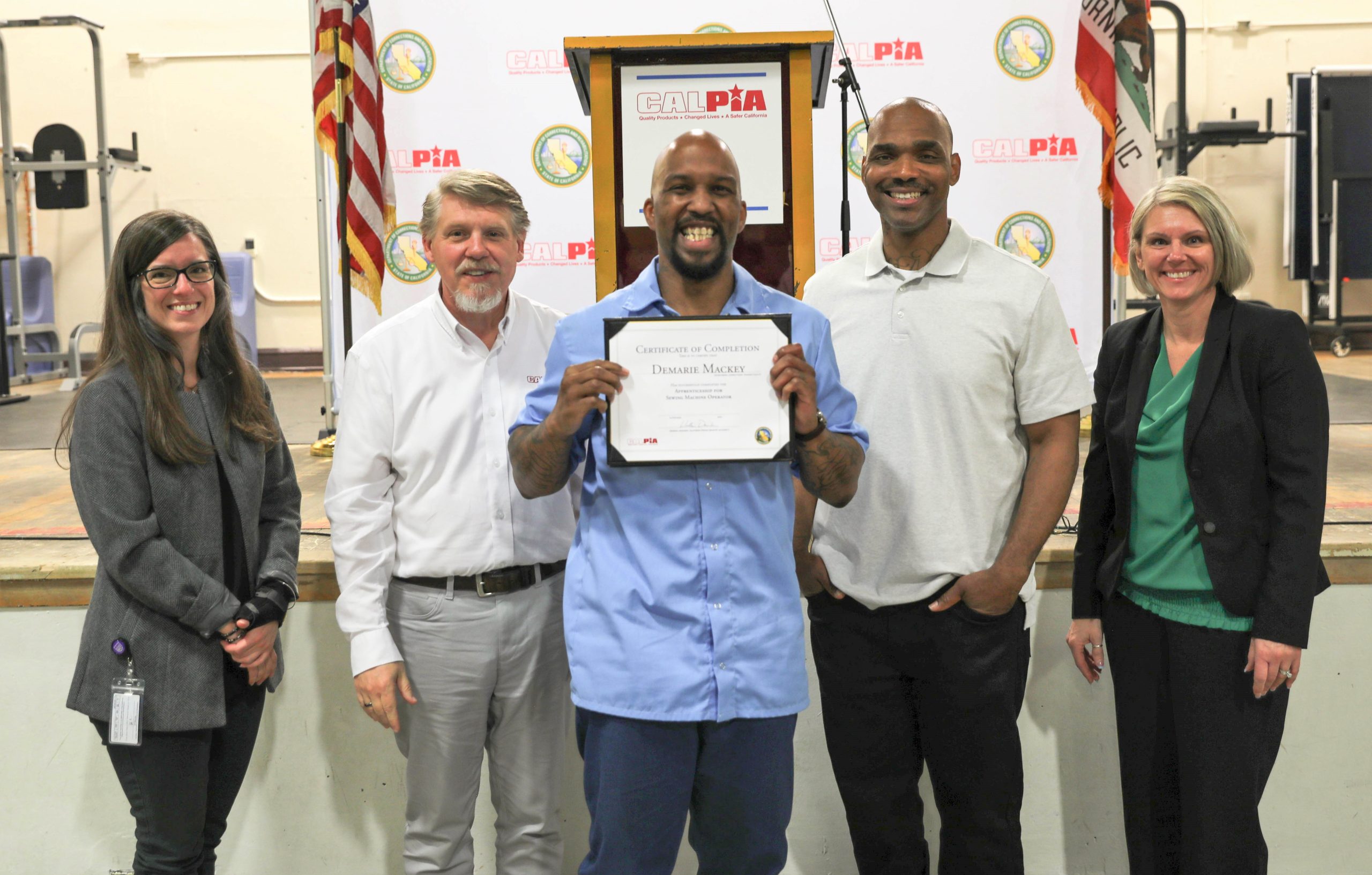 CALPIA CTF graduation for job certifications and apprenticeships. Image shows a graduate with staff and a guest speaker.