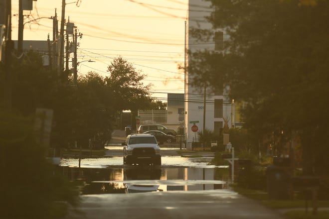 Residents and others look over the standing flood waters that remain around the Carolina Beach Lake area Tuesday Sept. 17, 2024 in Carolina Beach, N.C. KEN BLEVINS/STARNEWS