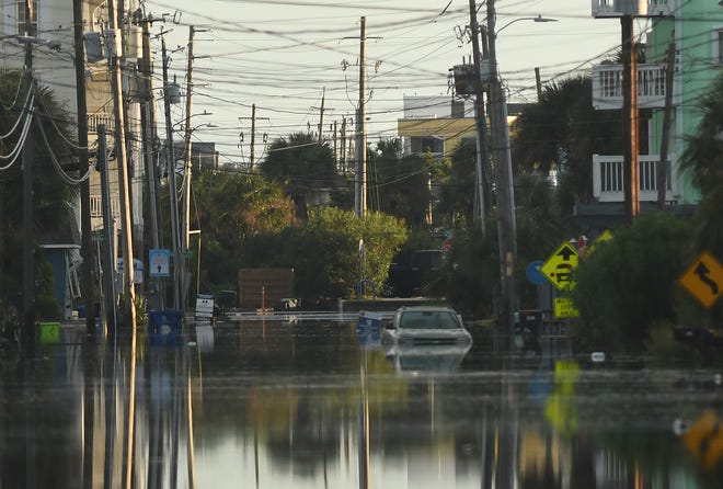 Residents and others look over the standing flood waters that remain around the Carolina Beach Lake area Tuesday Sept. 17, 2024 in Carolina Beach, N.C. KEN BLEVINS/STARNEWS