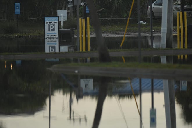 Residents and others look over the standing flood waters that remain around the Carolina Beach Lake area Tuesday Sept. 17, 2024 in Carolina Beach, N.C. KEN BLEVINS/STARNEWS