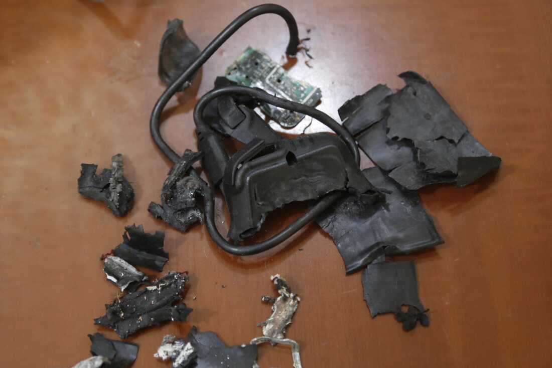 This photo, taken September 18, 2024, in Beirut's southern suburbs, shows the remains of exploded pagers on display at an undisclosed location. The remains are primarily black and look like damaged fragments of electronic devices.