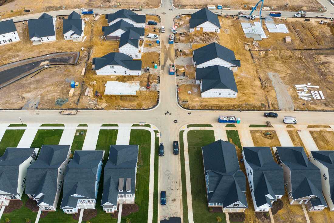 This aerial photo shows completed and under-construction new homes in Trappe, Maryland, in 2022. Some of the completed homes have green lawns. The homes still under constructions are on dirt lots.