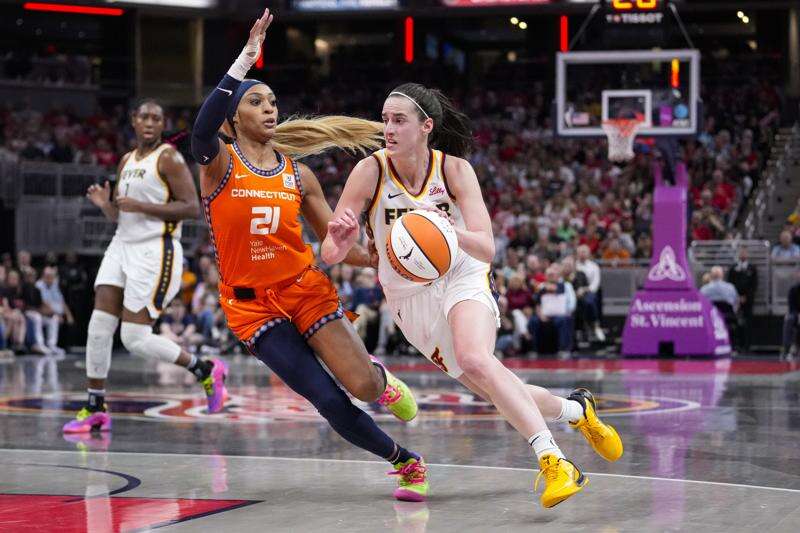 Indiana Fever guard Caitlin Clark (22) drives on Connecticut Sun guard DiJonai Carrington (21) in the second half of a WNBA basketball game in Indianapolis, Wednesday, Aug. 28, 2024. (AP Photo/Michael Conroy)