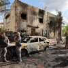 First responders and Israeli security forces gather amid debris and charred vehicles in Kiryat Bialik in the Haifa district of Israel, following a strike by Lebanon's Hezbollah on Sunday.