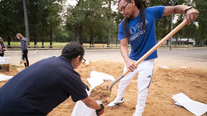 TALLAHASSEE, FLORIDA - SEPTEMBER 25: Jordan Rochester, right, and Kyley Weems bag sand in preparation for possible flooding on September 25, 2024 in Tallahassee, Florida. Forecasts predict Tropical Storm Helene will strengthen to a hurricane, making landfall along the Florida Gulf Coast on Thursday. (Photo by Sean Rayford/Getty Images)