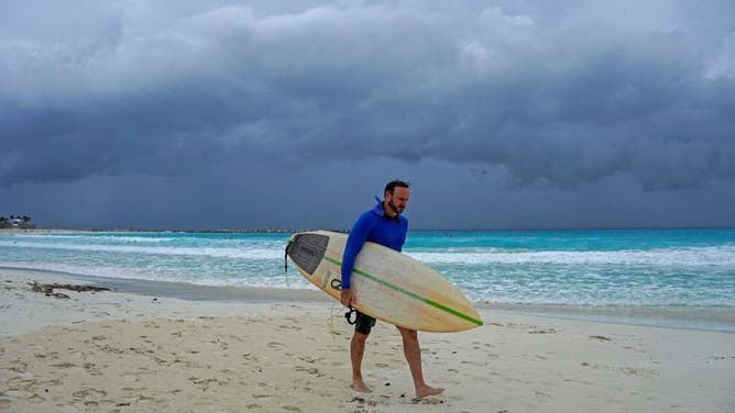 A surfer leaves the beach ahead of the arrival of Hurricane Helene in Cancun, Quintana Roo state, Mexico on September 24, 2024.