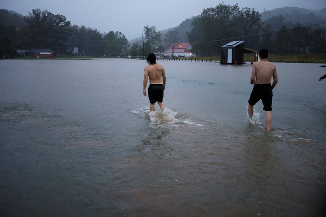 Residents walk through a flooded field as they play outside in the rain, as Hurricane Helene approaches in the North Carolina mountains, in Valle Crucis, North Carolina, U.S. September 26, 2024.