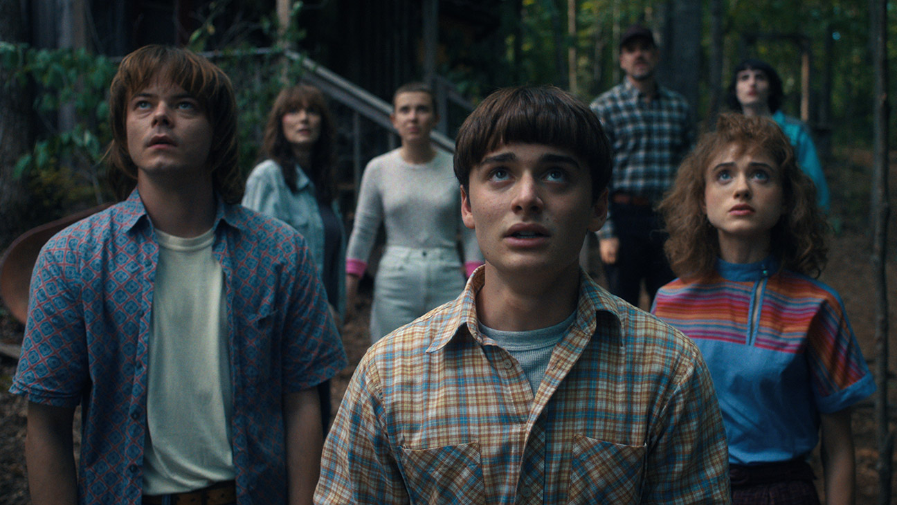 (L to R) Charlie Heaton as Jonathan Byers, Winona Ryder as Joyce Byers, Millie Bobby Brown as Eleven, Noah Schnapp as Will Byers, David Harbour as Jim Hopper, Natalia Dyer as Nancy Wheeler, and Finn Wolfhard as Mike Wheeler in STRANGER THINGS.