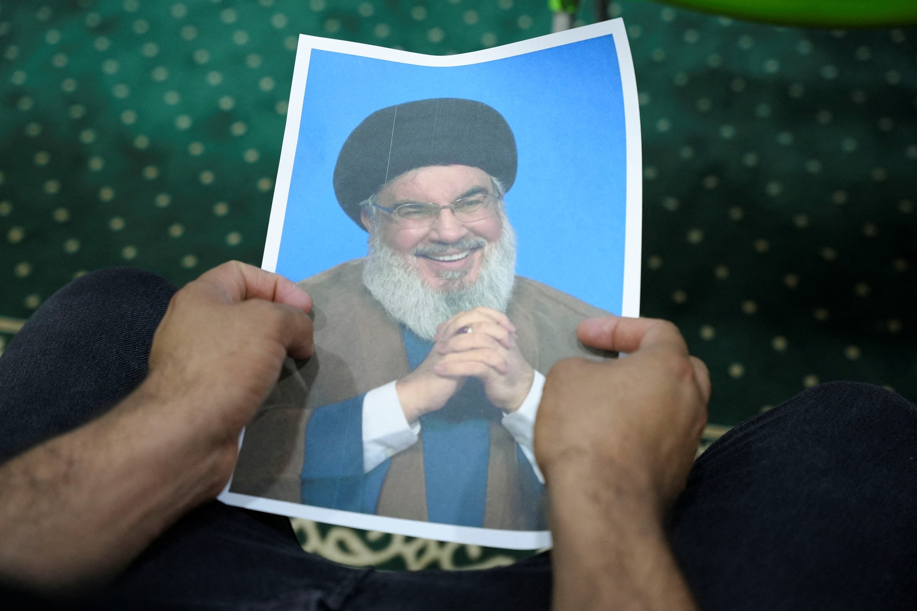 PHOTO: An Iraqi volunteer holds a picture of Lebanon's Hezbollah leader Sayyed Hassan Nasrallah, who has been killed, in Basra, Iraq, on Sept. 27, 2024. 