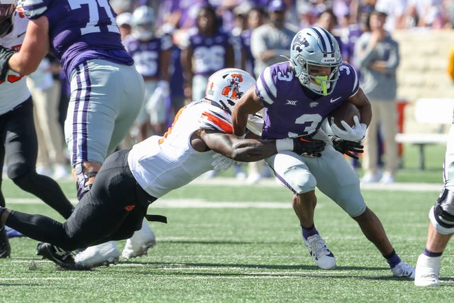 Kansas State running back Dylan Edwards (3) is brought down by Oklahoma State's Nick Martin (4) during the first quarter Saturday at Bill Snyder Family Stadium.