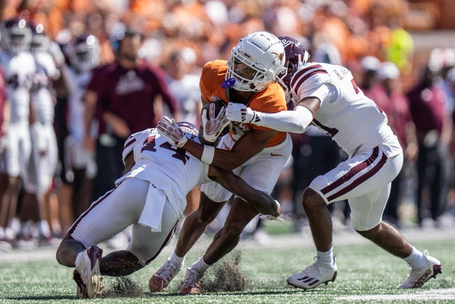 Texas receiver Isaiah Bond fights for yardage in Saturday's game after hauling in a catch from Arch Manning against Mississippi State at Royal-Memorial Stadium in Austin Saturday.