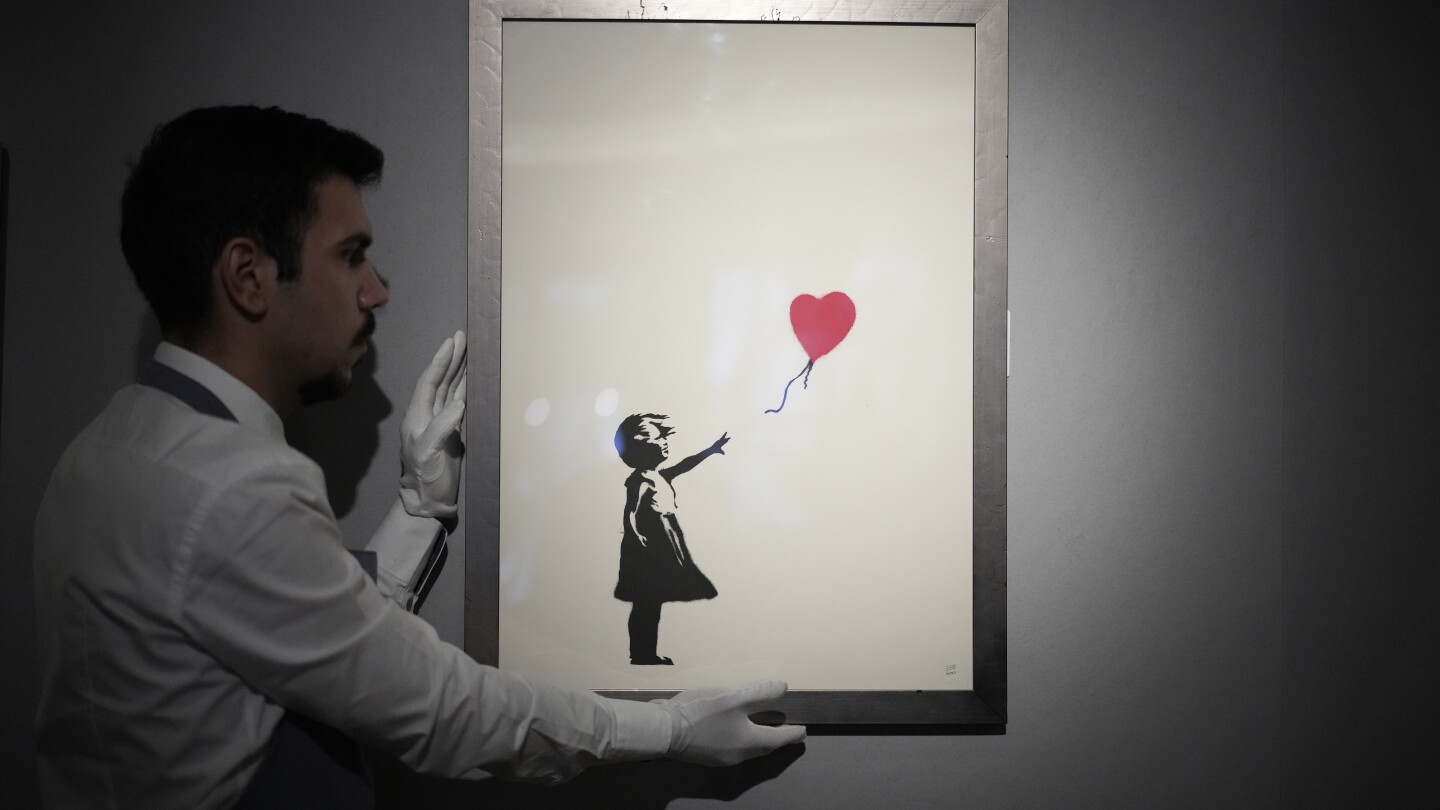 2 men charged with stealing a famous Banksy image from a London art gallery