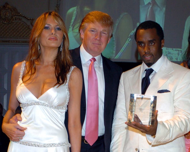 Sean 'P. Diddy' Combs (R) accepts an award from the Rush Philanthropic Foundation from Donald Trump and his wife Melania (L) at Mar-A-Lago Club in Palm Beach, Florida on March 11, 2005.