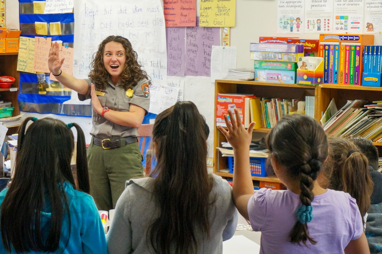 park ranger gesturing while presenting to students in a school classroom