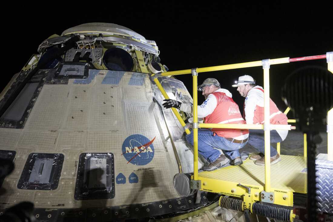 This handout image supplied by NASA shows Boeing and NASA teams work around NASA's Boeing Crew Flight Test Starliner spacecraft after it landed uncrewed at White Sands Space Harbor, on Friday at White Sands, N.M.