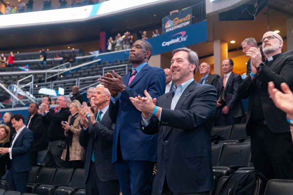 Dikembe Mutombo in a suit and tie in Capital One Arena