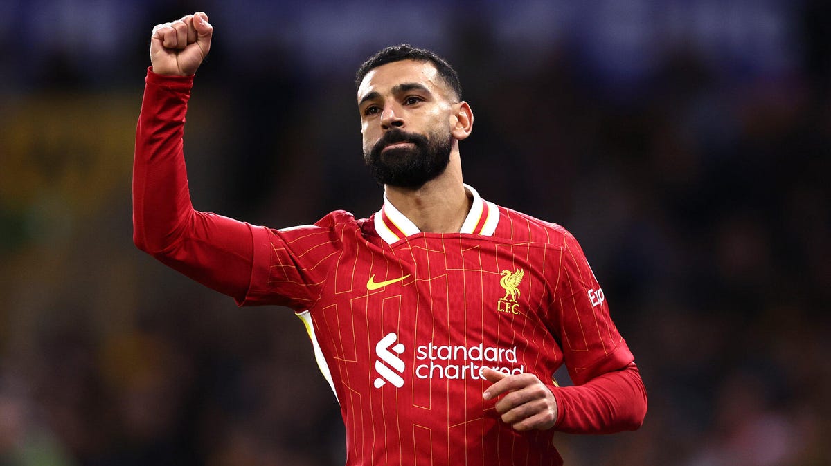 Liverpool attacker Mohamed Salah celebrating, with his right arm raised.