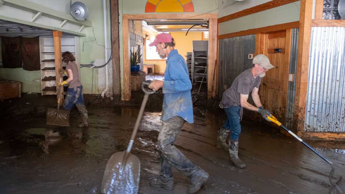 Residents work hard to shovel the mud out of the town's natural grocery store. French Broad River, which runs through the town of Marshall, crested over 24 feet during Hurricane Helene. The river level has gone down, but left behind knee-deep sediment inside the buildings.