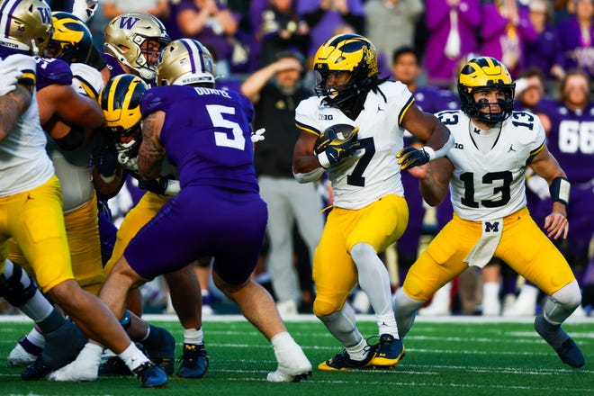 Michigan Wolverines running back Donovan Edwards takes a handoff from quarterback Jack Tuttle and runs for a 39-yard touchdown against the Washington Huskies during the second quarter at Husky Stadium on Oct. 5, 2024 in Seattle.