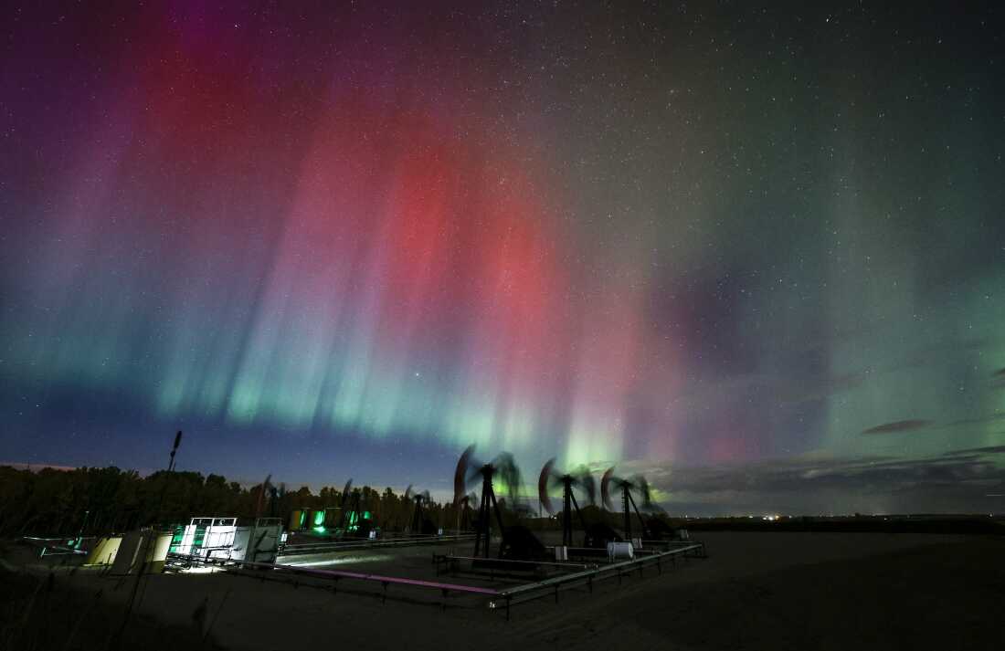 An aurora borealis makes an appearance over pumpjacks as they draw out oil and gas from well heads near Cremona, Alberta, Canada, on Oct. 10.