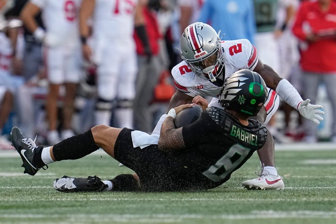 Ohio State safety Caleb Downs tackles Oregon quarterback Dillon Gabriel after a 3-yard gain. OSU failed to sack Gabriel during Saturday's 32-31 loss.