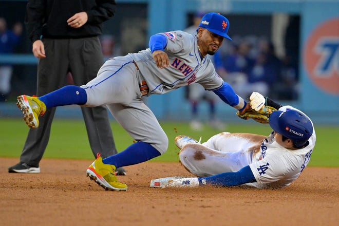 New York Mets shortstop Francisco Lindor (12) gets the tag on Los Angeles Dodgers two-way player Shohei Ohtani (17) attempting to steal second base in the second inning during game one of the NLCS for the 2024 MLB Playoffs on Oct. 13, 2024, at Dodger Stadium.