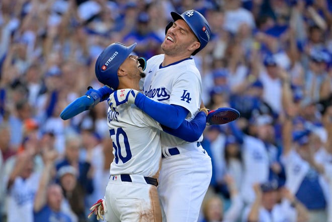 Oct 13, 2024; Los Angeles, California, USA; Los Angeles Dodgers first base Freddie Freeman (5) reacts with shortstop Mookie Betts (50) after scoring against the New York Mets during the first inning in game one of the NLCS for the 2024 MLB Playoffs on Oct. 13, 2024, at Dodger Stadium.