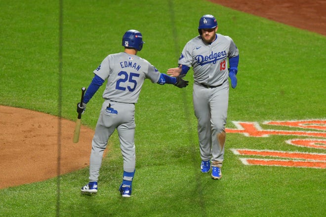 Los Angeles Dodgers third baseman Max Muncy (13) reacts with outfielder Tommy Edman (25) after scroing a run against the New York Mets in the second inning during game three of the NLCS for the 2024 MLB playoffs on Oct. 16, 2024, at Citi Field.