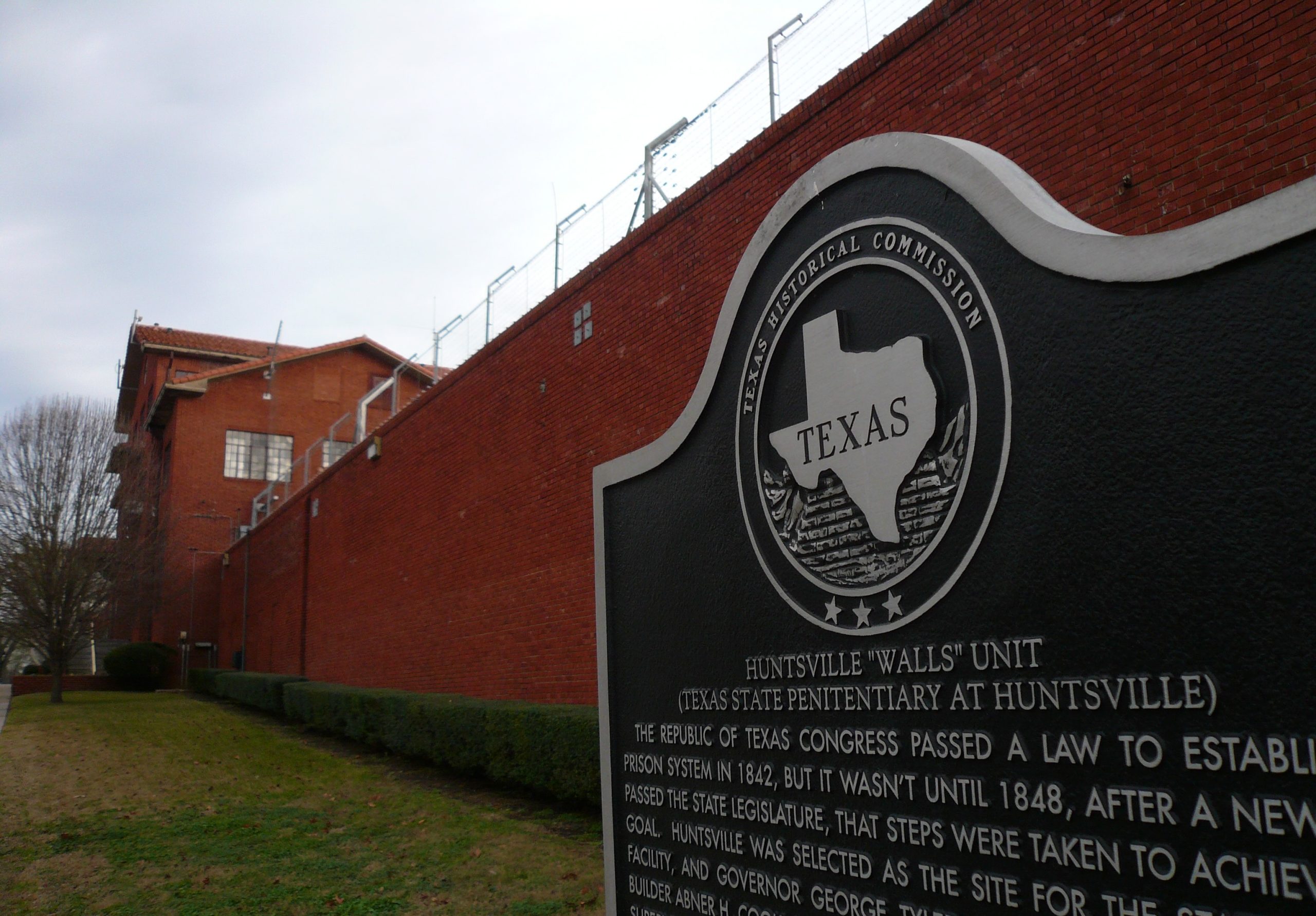 A sign and the exterior wall of the Hunstville prison