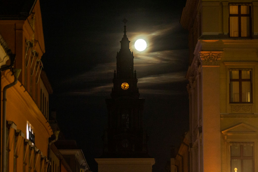 A yellow sphere behind a dark clock tower