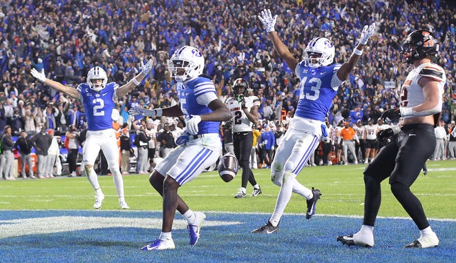 PROVO, UT - OCTOBER 18: Chase Roberts #2 and Jojo Phillips #13 of the Brigham Young Cougars celebrate as teammate Darius Lassiter #5 of the carries the ball into the endzone for the game winning touchdown against Jeff Roberson #22 of the Oklahoma State Cowboys during the second half of their game at LaVell Edwards Stadium on October 18, 2024 in Provo, Utah.(Photo by Chris Gardner/Getty Images)