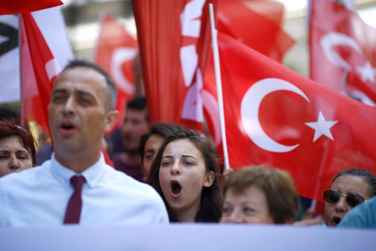 Demonstrators wave Turkish flags as they shout slogans