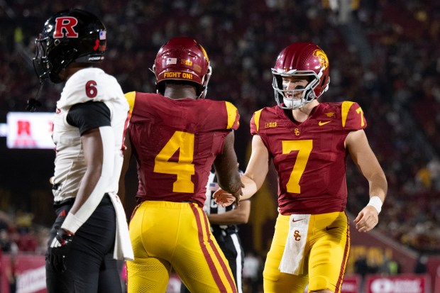 USC quarterback Miller Moss, right, celebrates a touchdown by running...