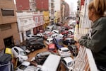 A woman looks out from her balcony as vehicles are trapped in the street during flooding in Valencia, Wednesday.