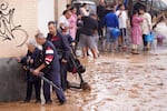 People walk through flooded streets in Valencia, Spain, Wednesday, Oct. 30, 2024.