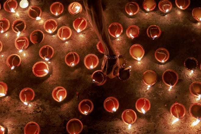 A devotee prepares to place oil lamps at a religious ceremony during the Diwali festival at Ponnambalavaneshwaram Hindu temple in Colombo, Sri Lanka November 12,2023.