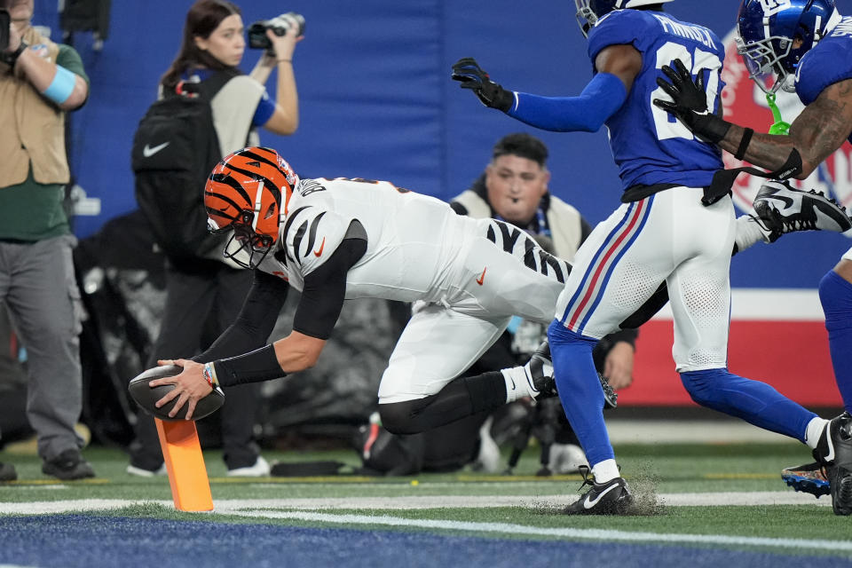 Cincinnati Bengals quarterback Joe Burrow scores a touchdown as New York Giants safety Jason Pinnock (27) and linebacker Isaiah Simmons (19) move in on the play during the first half of an NFL football game against the New York Giants, Sunday, Oct. 13, 2024, in East Rutherford, N.J. (AP Photo/Frank Franklin II)