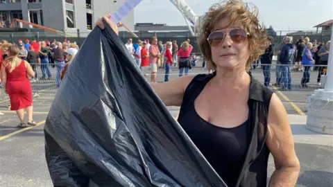 A woman holding a rubbish bag