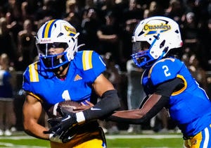 Catholic Memorial running back Corey Smith (1) takes a handoff from quarterback MJ Mitchell (2) during the season opener against Franklin at Waukesha South on Friday, August 18, 2023.