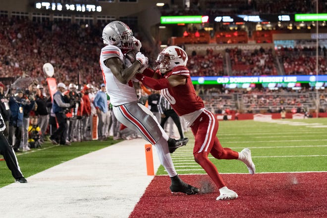 Oct 28, 2023; Madison, Wisconsin, USA; Ohio State Buckeyes wide receiver Marvin Harrison Jr. (18) catches a pass to score a touchdown as Wisconsin Badgers cornerback Nyzier Fourqurean (10) defends during the third quarter at Camp Randall Stadium. Mandatory Credit: Jeff Hanisch-USA TODAY Sports