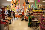 Customers shop while Yamely Chavez Kennedy buils her ofrenda at Colima Market in Bend, Ore., on Oct. 30, 2024.